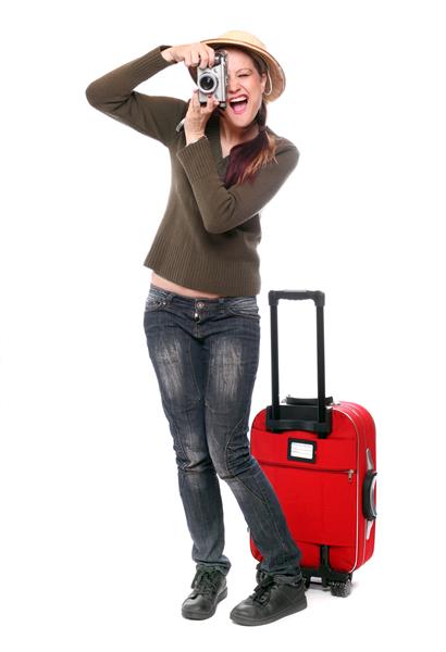 مسافر خوشحال با دوربین و چمدان که به تعطیلات می رود