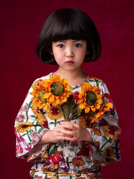 دختر بچه چینی با گل های آفتابگردان