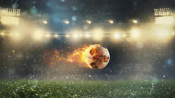 نمای نزدیک از یک توپ فوتبال آتشین که با قدرت در استادیوم پرتاب شد