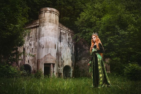 زن مو قرمز با لباس سبز قرون وسطایی در نزدیکی قلعه