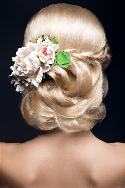 پرتره یک زن بلوند زیبا در تصویر عروس با گل در موهایش عکس گرفته شده در استودیو بر روی پس زمینه سیاه چهره زیبایی و مدل موی نمای پشت