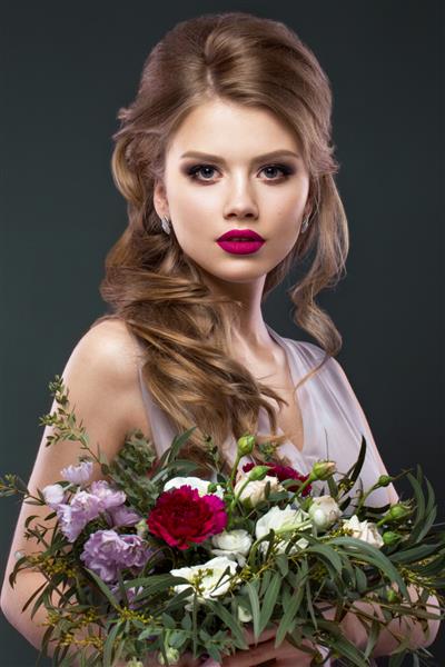 پرتره زن زیبا در تصویر عروس با گل در دستان عکس گرفته شده در استودیو زیبایی چهره و مدل مو