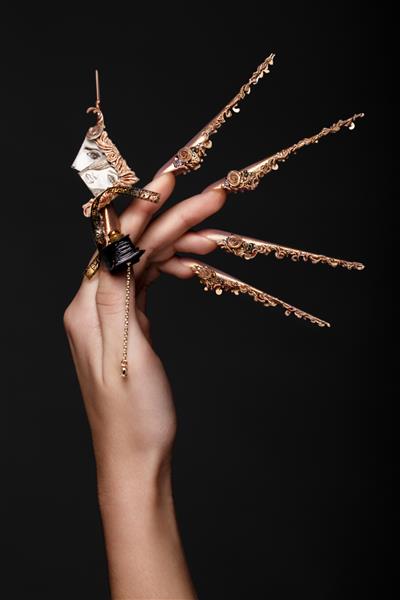 طراحی خلاقانه ناخن روی دست های زن عکس مانیکور هنری که در استودیو گرفته شده است