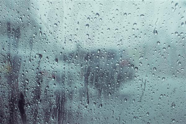 باران آب را روی پس‌زمینه شیشه ماشین می‌ریزد نمای بیرون از ماشین پس‌زمینه در حال باریدن سطح ماشین از پنجره شیشه‌ای با قطره آب باران در روز بارانی