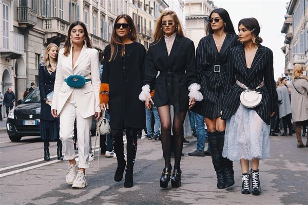 میلان ایتالیا - 24 فوریه 2018 مدل های شیک پوش وبلاگ نویسان و اینفلوئنسرها در حال ژست گرفتن و قدم زدن در خیابان بعد از نمایش Ermanno Scervino در طول نمایش مد میلان