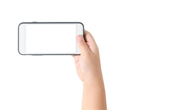 تلفن همراه با دست کودک با صفحه سفید خالی جدا شده در پس زمینه سفید مسیر برش