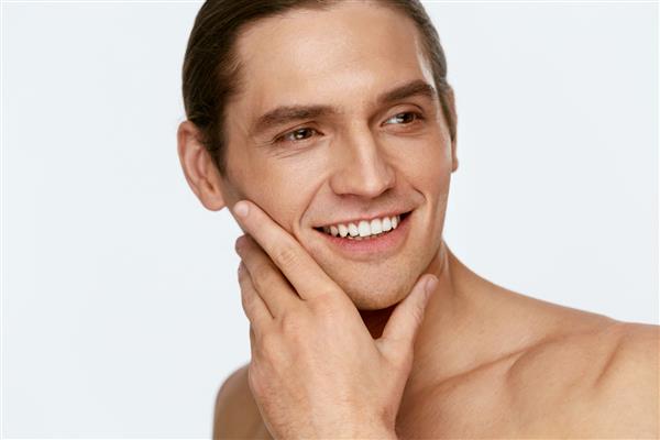 مراقبت از صورت مردانه مردی که پوست صاف را بعد از اصلاح لمس می کند