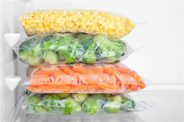 کیسه های پلاستیکی با سبزیجات منجمد عمیق در یخچال