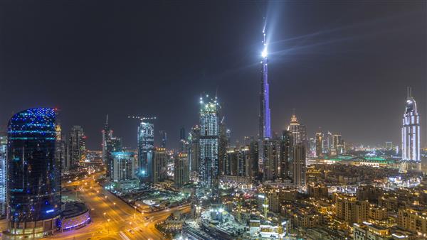 منظره شهری در مرکز شهر دبی با برج خلیفه لایت‌آپ لایت تایم لپس هوایی از پشت بام با بزرگترین نمایش نور و صدا در یک ساختمان واحد امارات متحده عربی شهر دبی دارد