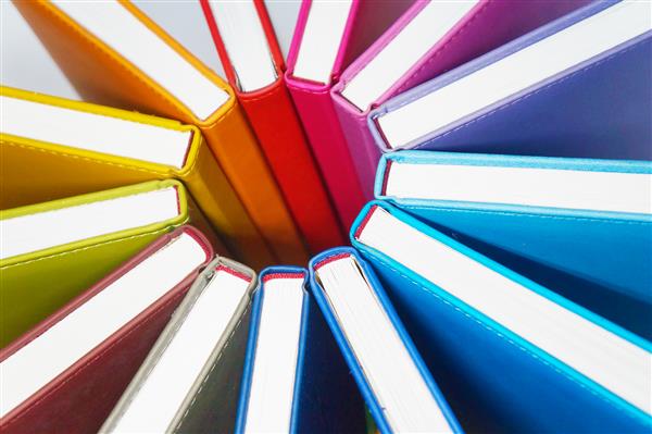 کتاب برای پس زمینه رنگارنگ تعداد زیادی کتاب با جلدهای روشن که به صورت دایره ای ردیف شده اند عنصر طراحی بافت کاغذ و چرم نمای نزدیک