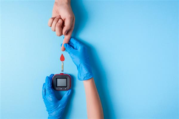 پرستار در حال انجام آزمایش خون دست مرد با قطره خون قرمز با نوار تست قند خون و گلوکز متر فضای کپی نمای بالا