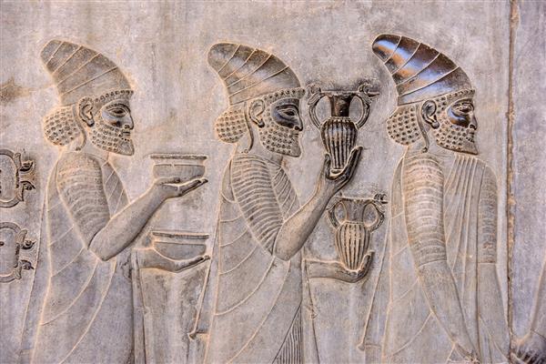 نقش برجسته سفیران را نشان می دهد که هدایایی برای پادشاه حمل می کنند نقش برجسته باستانی بر روی دیوار شهر ویران شده تخت جمشید پرسپولیس ایران