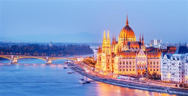 خط افق بوداپست مجارستان - پارلمان مجارستان روشن در گرگ و میش منظره پانورامایی دیدنی از دلتای رودخانه دانوب و پل مقصد معروف سفر اروپا