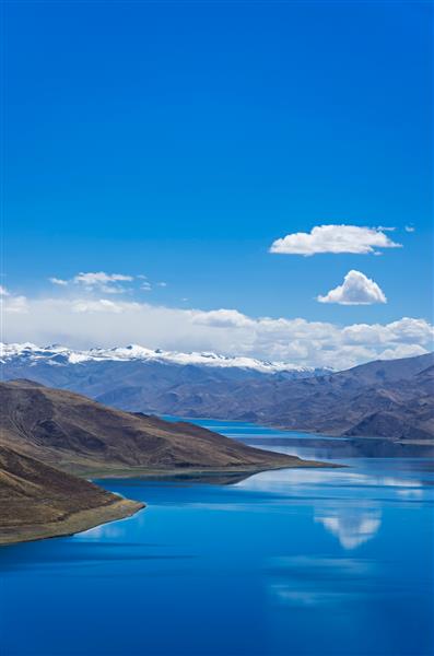 دریاچه یامدروک پنجمین دریاچه بزرگ تبت چین دریاچه آبی زیبا در مرتفع ترین زمین با کوه های زیر آسمان آبی و ابرهای سفید نقطه عطف تبت