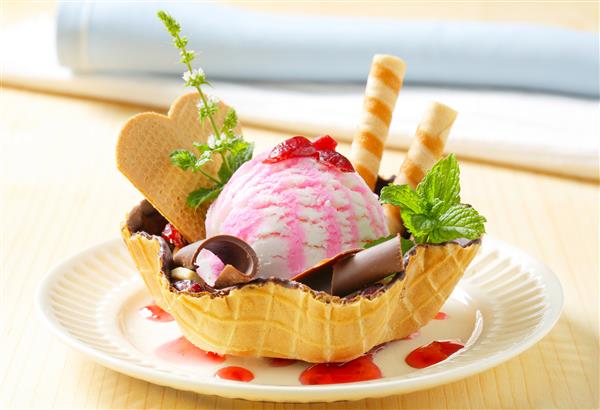 دسر بستنی دوست داشتنی که با فرهای شکلاتی و ویفر تزئین شده است