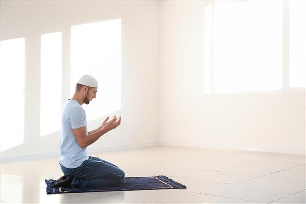 مرد جوان مسلمان در حال نماز در خانه