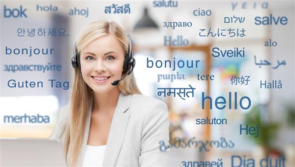 مفهوم ترجمه تجارت و فناوری - مترجم یا اپراتور زن خندان در هدست در دفتر بر روی کلمات تبریک به زبان های مختلف خارجی
