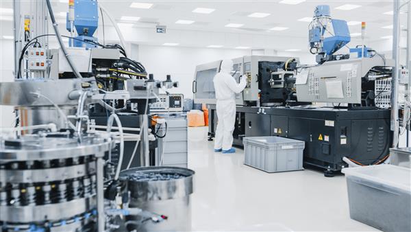 در مورد یک دانشمند کارخانه در لباس های محافظ استریل روی ماشین آلات چاپ سه بعدی صنعتی مدرن کار می کند فرآیند تولید داروسازی بیوتکنولوژی و نیمه هادی از داخل عکس گرفته شده است