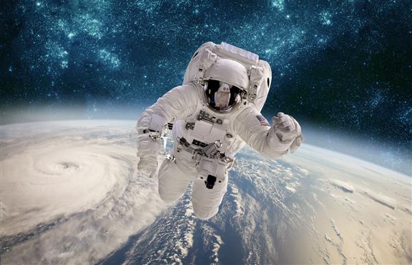 فضانورد در فضای بیرونی در پس زمینه سیاره زمین طوفان بر فراز سیاره زمین عناصر این تصویر توسط ناسا ارائه شده است