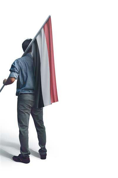 مرد جوانی که پرچم یمن را در زمینه سفید در دست دارد پرچم یمن