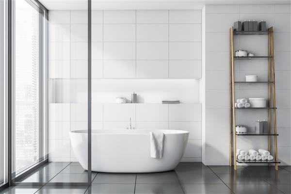 فضای داخلی حمام شیک با دیوارهای کاشی سفید کف کاشی خاکستری وان سفید راحت و قفسه هایی با حوله و کرم رندر سه بعدی