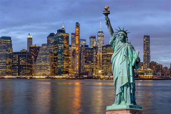 مجسمه آزادی بر فراز صحنه شهر نیویورک با پل بروکلین در کنار رودخانه شرقی در زمان گرگ و میش معماری و ساختمان با مفهوم توریستی ایالات متحده آمریکا ایالات متحده آمریکا