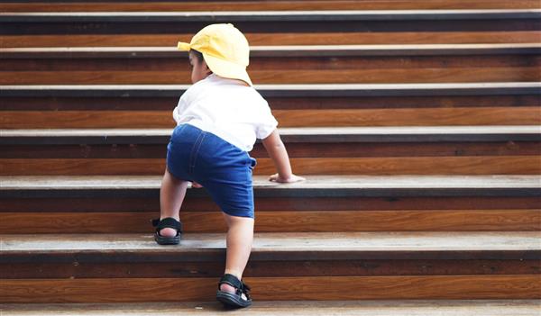 کوچولوی دوست داشتنی آسیایی 18 ماهه نوزاد پسر 1 7 ساله از پله های چوبی با علامت برچسب ذهن خود را قدم می گذارد بالا می رود بچه ای که سعی می کند از پله ها بالا برود