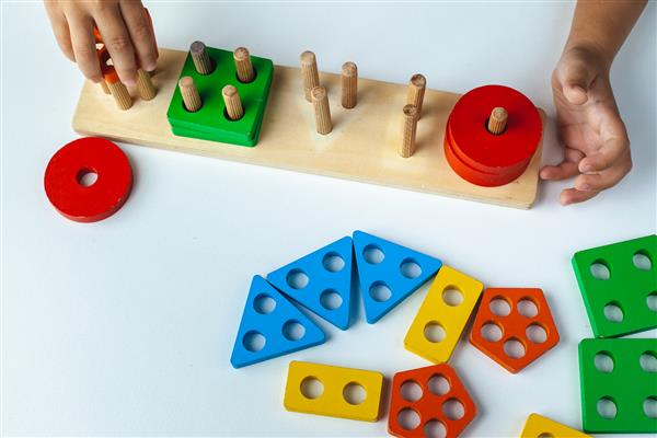 اسباب بازی چوبی بچه گانه کودک یک مرتب کننده جمع می کند اسباب بازی های منطقی آموزشی برای کودکان دست های کودکان از نمای نزدیک بازی های مونته سوری برای رشد کودک