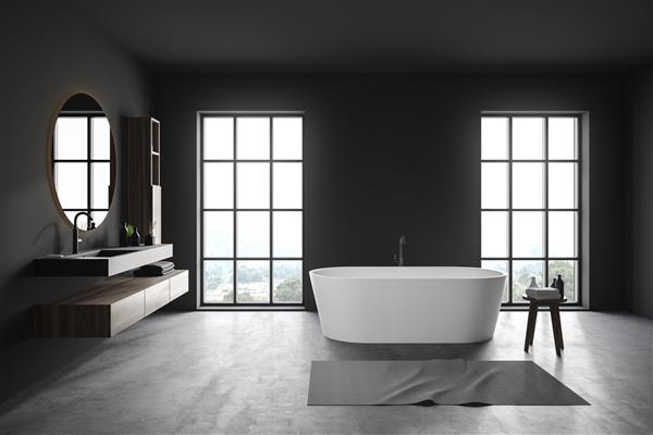 فضای داخلی حمام راحت با دیوارهای خاکستری کف بتونی پنجره های بزرگ وان حمام و سینک خاکستری با آینه گرد بالای آن رندر سه بعدی