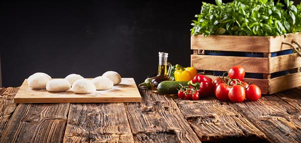 مواد تازه برای پیتزاهای گیاهی ایتالیایی با بخش‌های جداگانه خمیر خام روی سینی ریحان گوجه‌فرنگی فلفل دلمه‌ای برنجال و کدو سبز در یک بنر پانوراما با فضای کپی