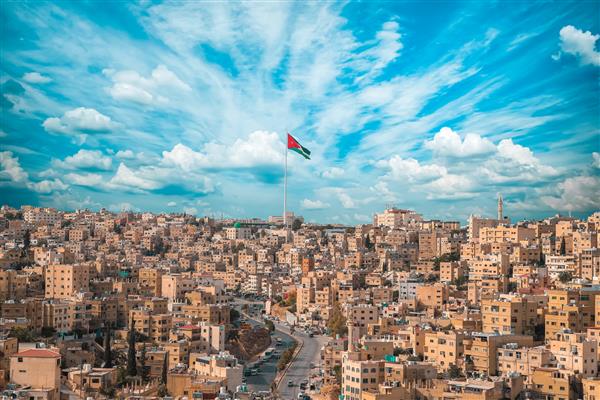 پرچم اردن در عمان نمای چشم انداز پس زمینه آسمان ابری