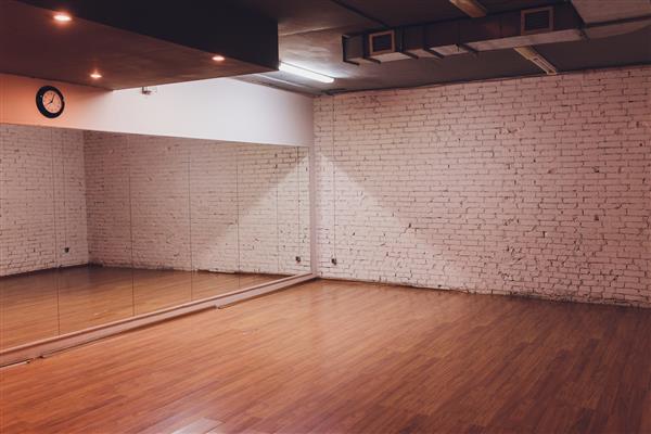 فضای داخلی یک استودیوی رقص و تناسب اندام خالی با طراحی لفت و آینه های بزرگ