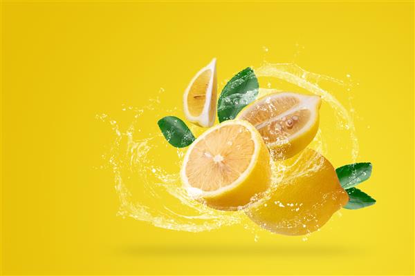 آب پاشیدن و میوه لیموی زرد در زمینه زرد