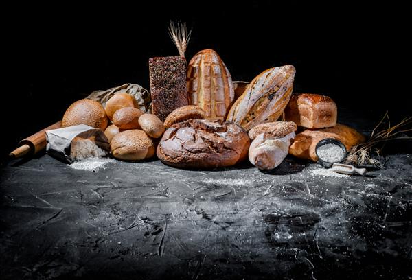 مجموعه ای از نان های تازه پخته شده در زمینه تیره نان سفید و چاودار نان با محل کپی