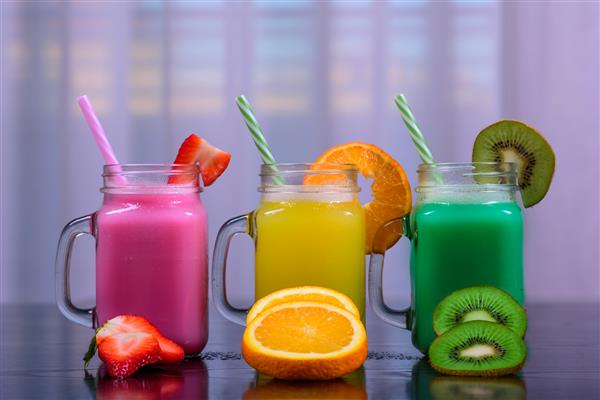 کوزه های آب میوه با اسموتی های رنگارنگ مختلف نوشیدنی سالم با انواع توت ها و میوه ها سبک زندگی سالم