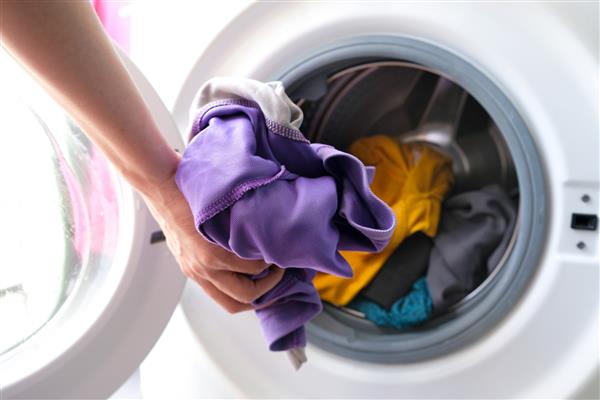 دست زن برداشتن لباس ماشین لباسشویی مفاهیم تمیز و سالم