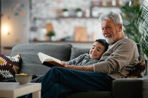 پدربزرگ و نوه در حال خواندن کتاب پدربزرگ و نوه در حال لذت بردن در خانه