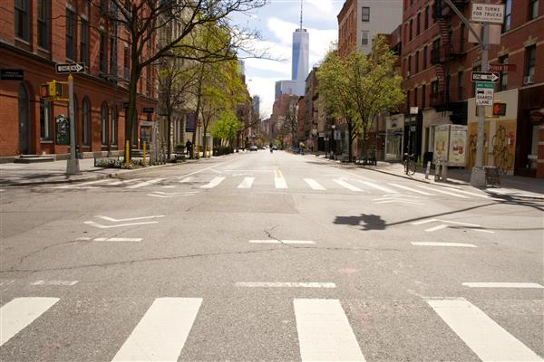 نیویورک نیویورک ایالات متحده آمریکا - 10 آوریل 2020 خیابان‌های معمولاً شلوغ در منهتن پایین عملاً خلوت هستند زیرا مقامات شهر نیویورک تعطیلی فروشگاه‌ها مشاغل و رستوران‌ها را برای COVID-19 اعمال کردند