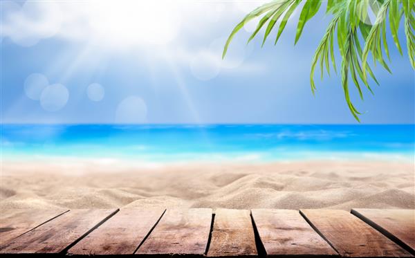 نمایش محصول میز چوبی با تعطیلات تابستانی پس‌زمینه تعطیلات ساحل استوایی دریای آبی ابرهای سفید نور خورشید و برگ‌های درخت نخل سبز