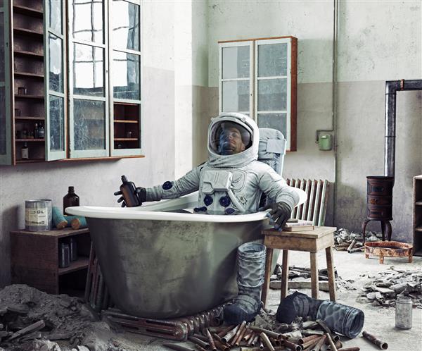 فضانوردی در حال استراحت در خانه در وان حمام تصویر ترکیبی عکس و رسانه