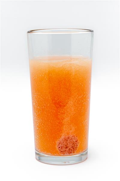مولتی ویتامین جوشان محلول در یک لیوان شیشه ای با آب در زمینه سفید