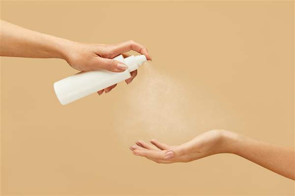 ضد عفونی کننده دست های زن با استفاده از اسپری ضد عفونی کننده برای جلوگیری از انتشار COVID روال بهداشت روزانه با محصولات آنتی باکتریال برای پیشگیری از ویروس و سالم ماندن