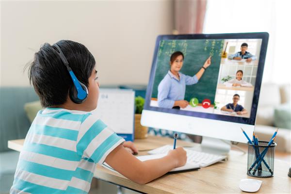 دانش آموز پسر آسیایی ویدئو کنفرانس آموزش الکترونیکی با معلم و همکلاسی ها در کامپیوتر در اتاق نشیمن در خانه آموزش در منزل و آموزش از راه دور آنلاین آموزش و اینترنت