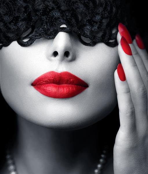 زن زیبا با ماسک توری مشکی روی چشمانش نزدیک لب ها و ناخن های سکسی قرمز دهان شهوانی مانیکور و آرایش مفهوم آرایش شور پرتره سیاه و سفید