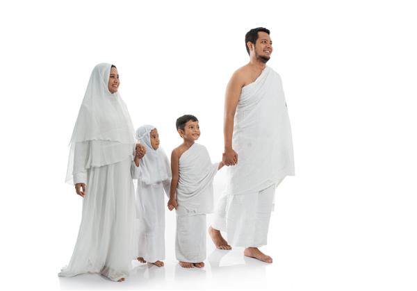 خانواده حج مسلمان و فرزندان در حال راه رفتن و دست گرفتن روی پس زمینه سفید جدا شده اند