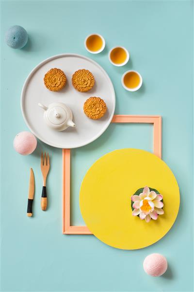 غذاها و نوشیدنی‌های فستیوال نیمه‌پاییز کیک ماه و چای روی زمین بی‌جان با پس‌زمینه پاستلی