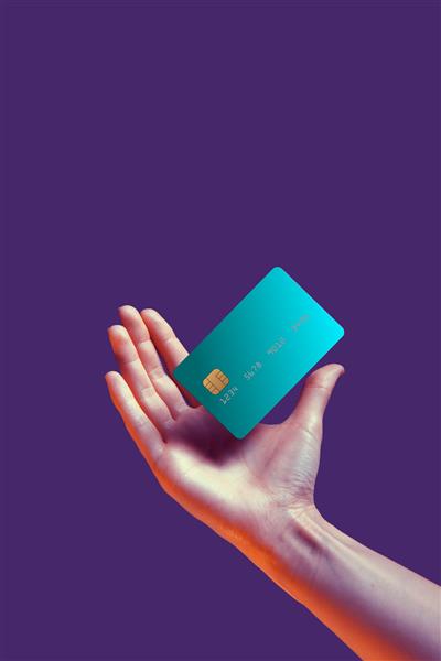 دست زن از نزدیک کارت اعتباری بانکی را با ماکت الگوی معلق نگه می‌دارد با سرویس آنلاین جدا شده روی پس‌زمینه بنفش