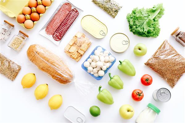 مجموعه ای از اقلام مواد غذایی از کنسرو سبزیجات غلات در پس زمینه سفید مفهوم تحویل غذا مفهوم اهدا نمای بالا