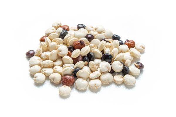 عکس ماکرو نزدیک از کینوا نپخته جدا شده در پس زمینه سفید دانه های کینوا سیاه قرمز و سفید غذای گیاهی مفهوم غذای سالم
