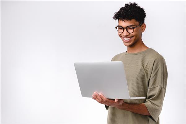 دانش آموز مختلط جوان باهوش با استفاده از لپ تاپ ایزوله شده روی پس زمینه سفید